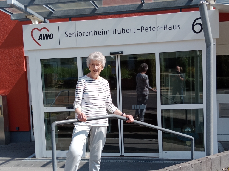 Renate Schilling steht vor dem Seniorenheim Hubert-Peter-Haus