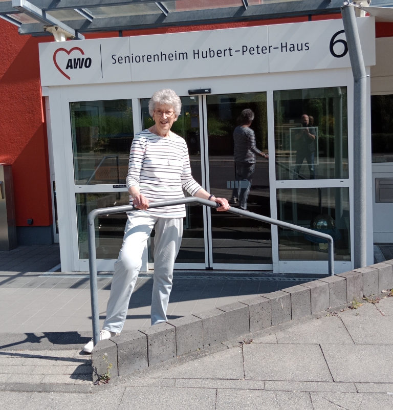 Renate Schilling steht vor dem Seniorenheim Hubert-Peter-Haus